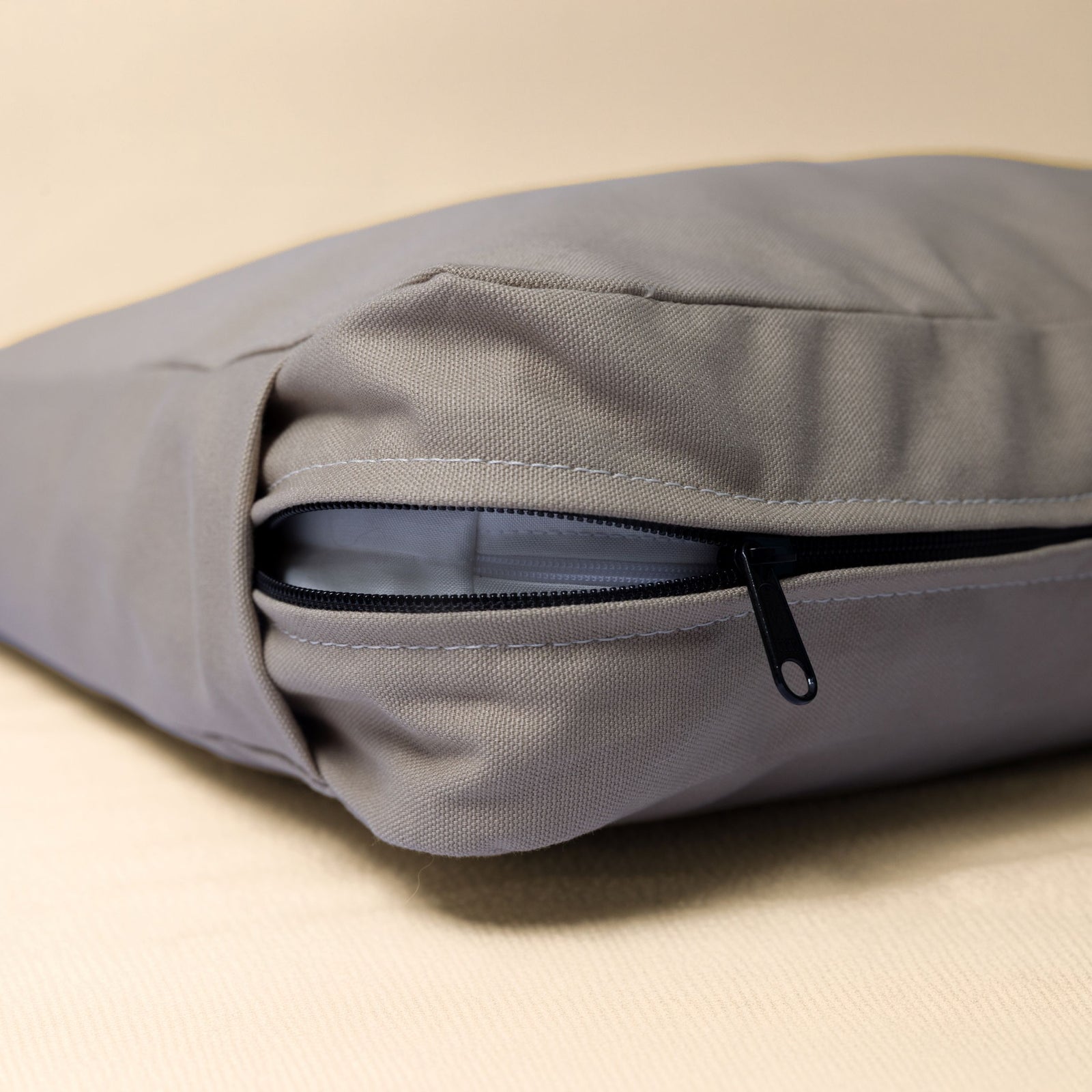 A close-up of The Classic Bed in Driftwood color showing zipper and stitching details.