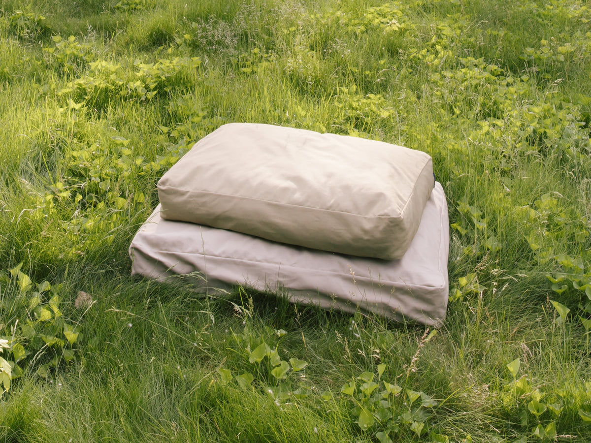 Moss and Driftwood Classic Beds stacked together in a grassy field.
