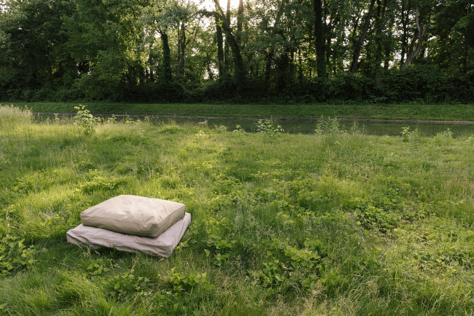 Moss and Driftwood Classic Beds stacked in a grassy field showcasing The Woolly Hound natural dog beds.